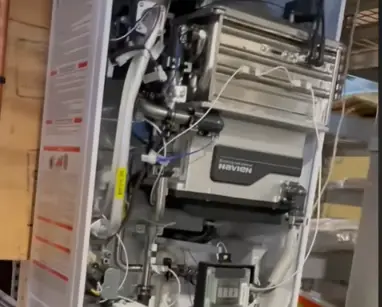 Inside view of a tankless water heater showing the burner and control parts