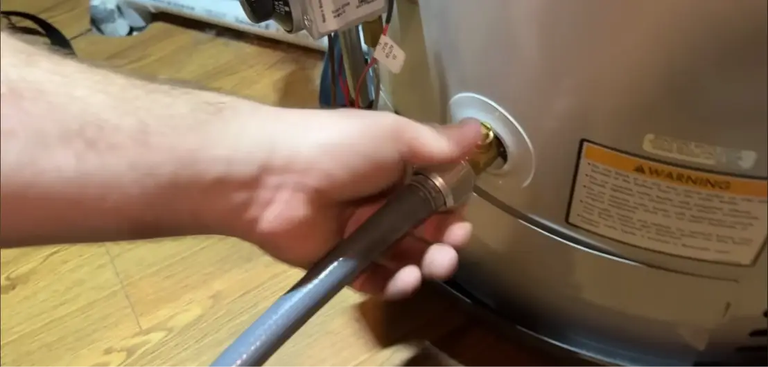 Garden hose connected to the drain valve of a water heater tank