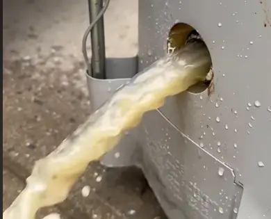 Murky water with sediment flowing out of a water heater drain valve