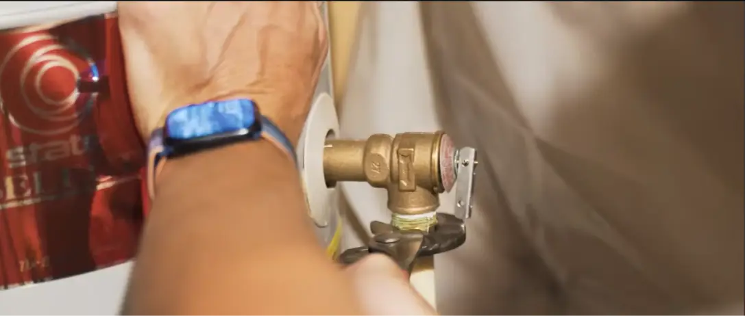 Hand on the temperature and pressure relief valve of a water heater